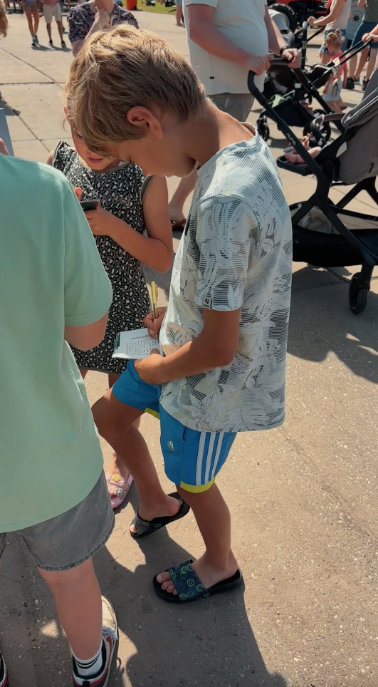 Kind activiteiten boekje invullen staand